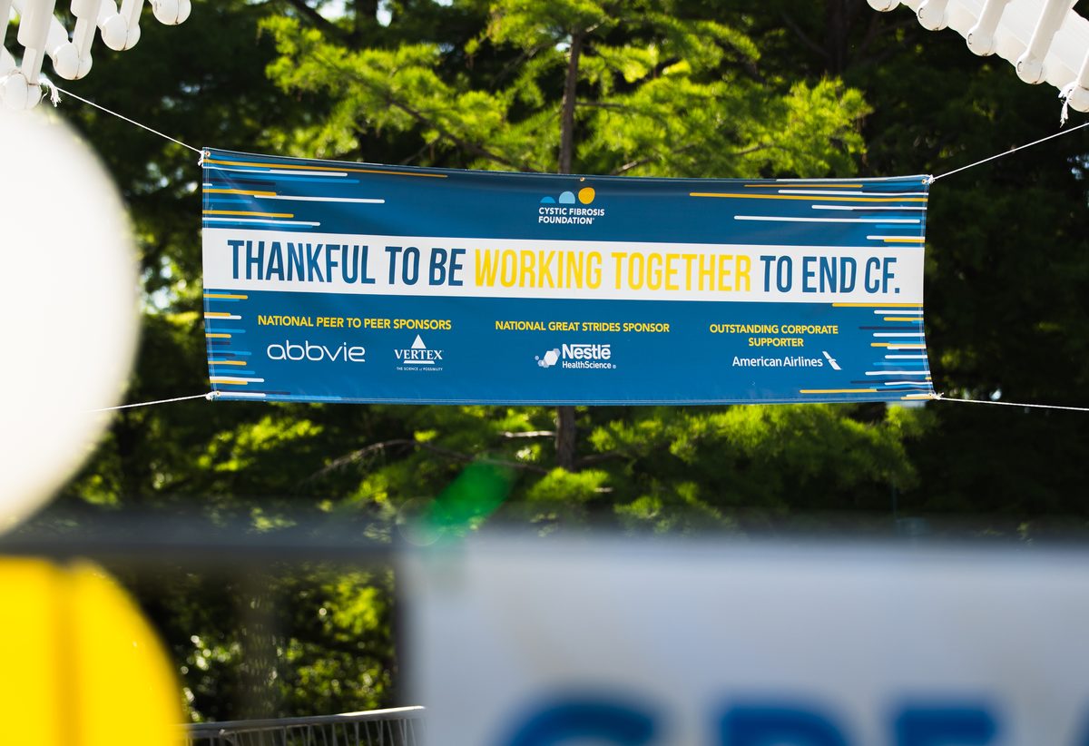 Team of walkers passing under a Cystic Fibrosis Foundation arch