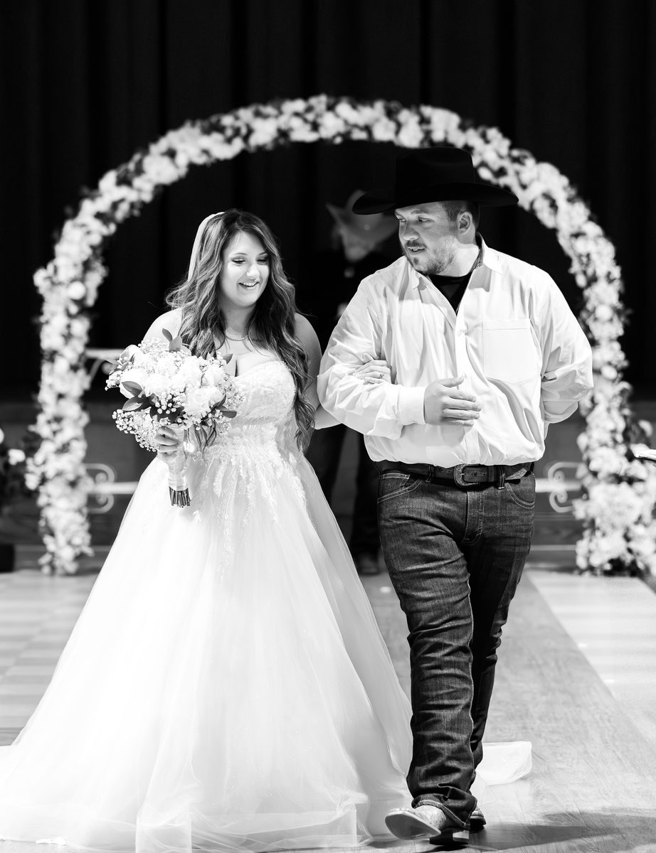 Bride smiling in her wedding dress with bouquet