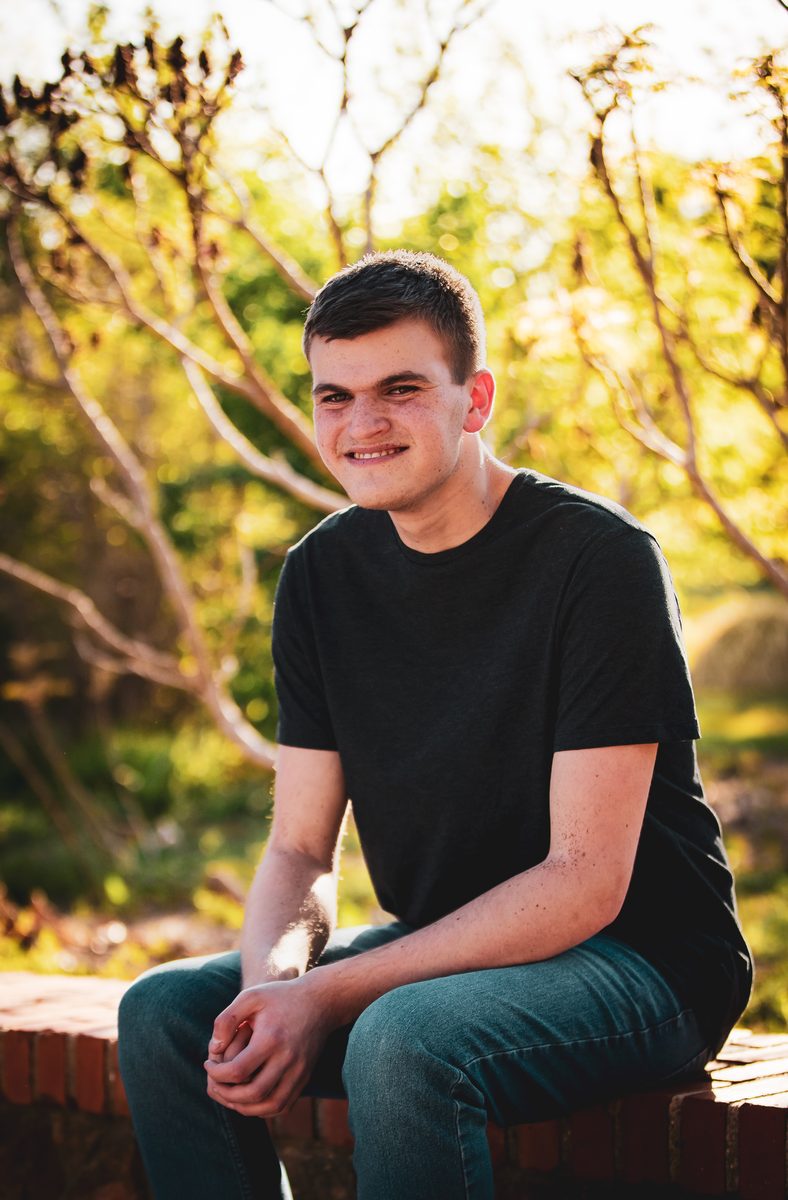 High school senior smiling for a portrait session outdoors