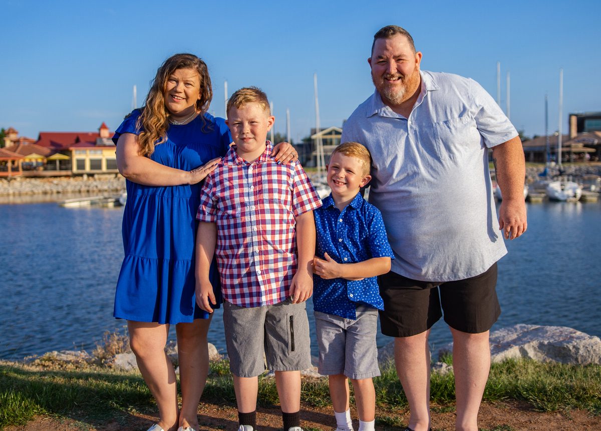 Family of four posing together at a marina