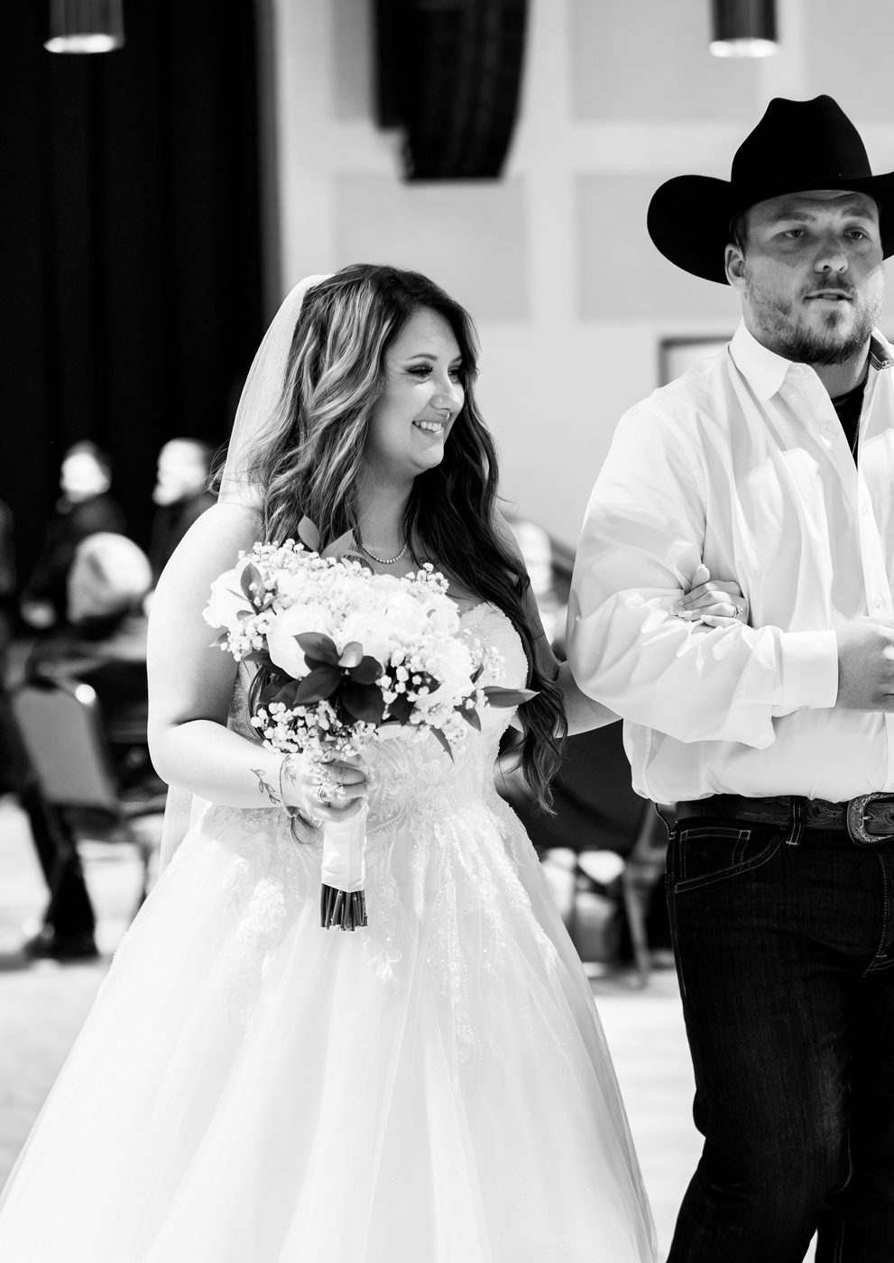 Bride smiling walking down the aisle with a groomsman