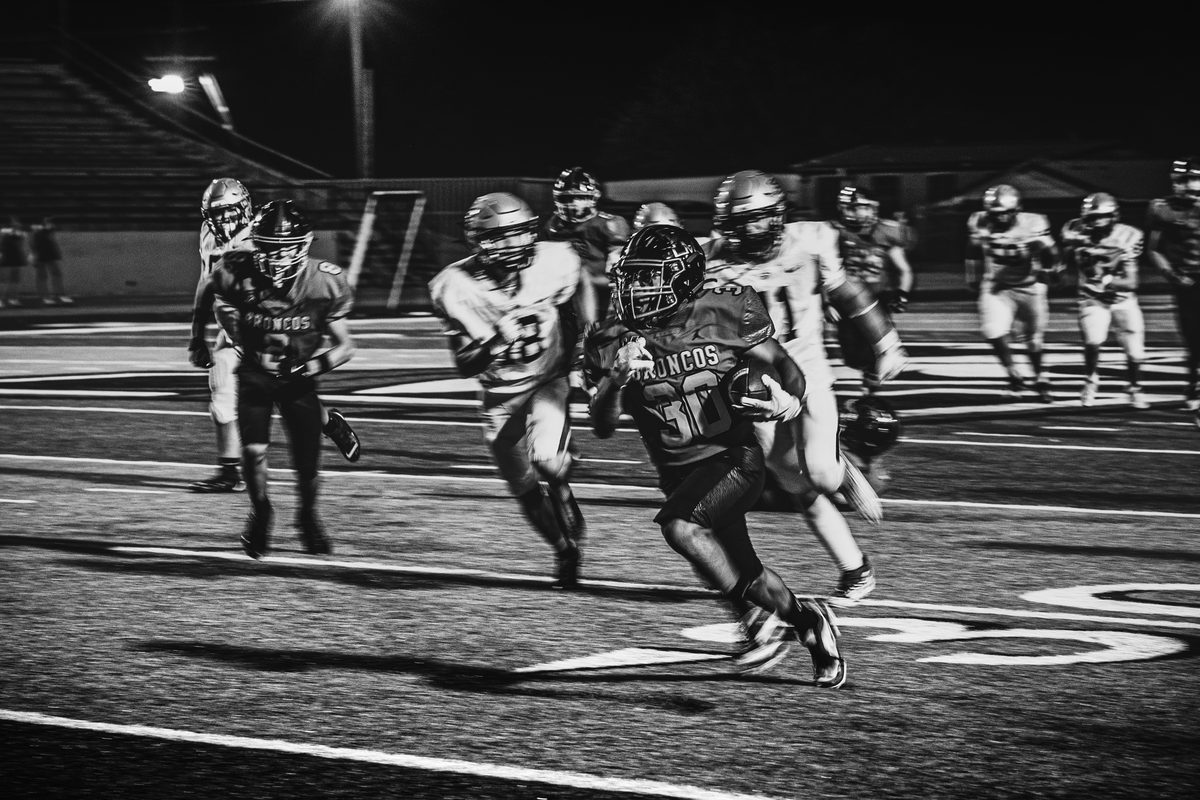 Football players in motion during a night game